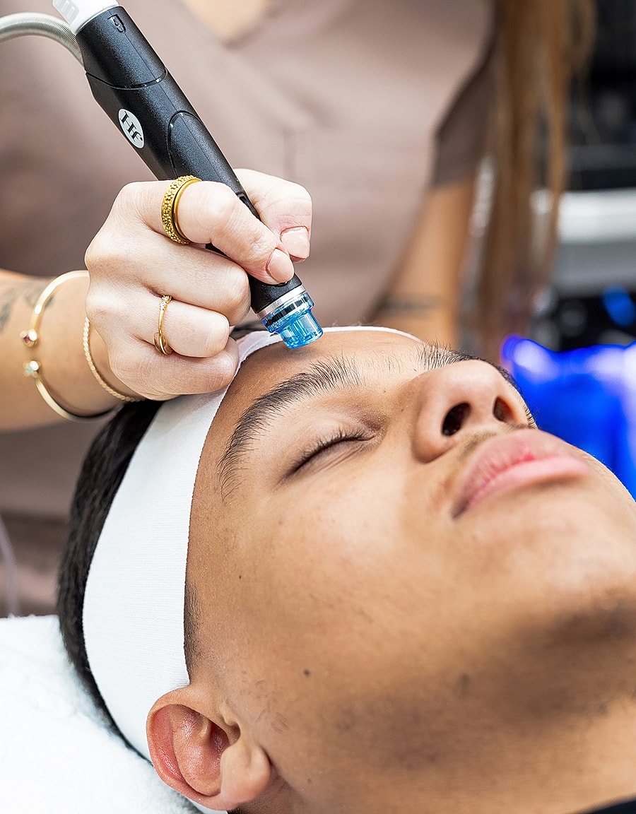 Person receiving a facial treatment with device.